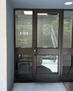 Glendale Clinic front door - glass with Desert Foot and Ankle logo, suite (E159) and Hours (Monday through Friday 8AM to 5PM), and phone 480-844-8218