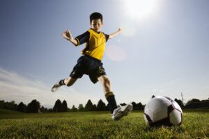 A soccer player, a boy preparing to kick a soccer ball.