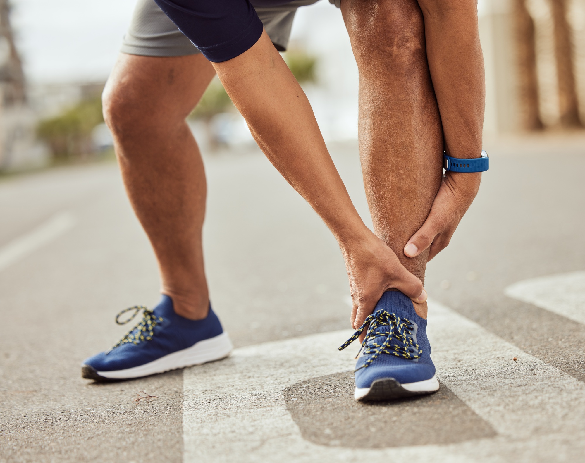 Fitness, pain in ankle and hands of black man with muscle ache, joint pain and injury after running