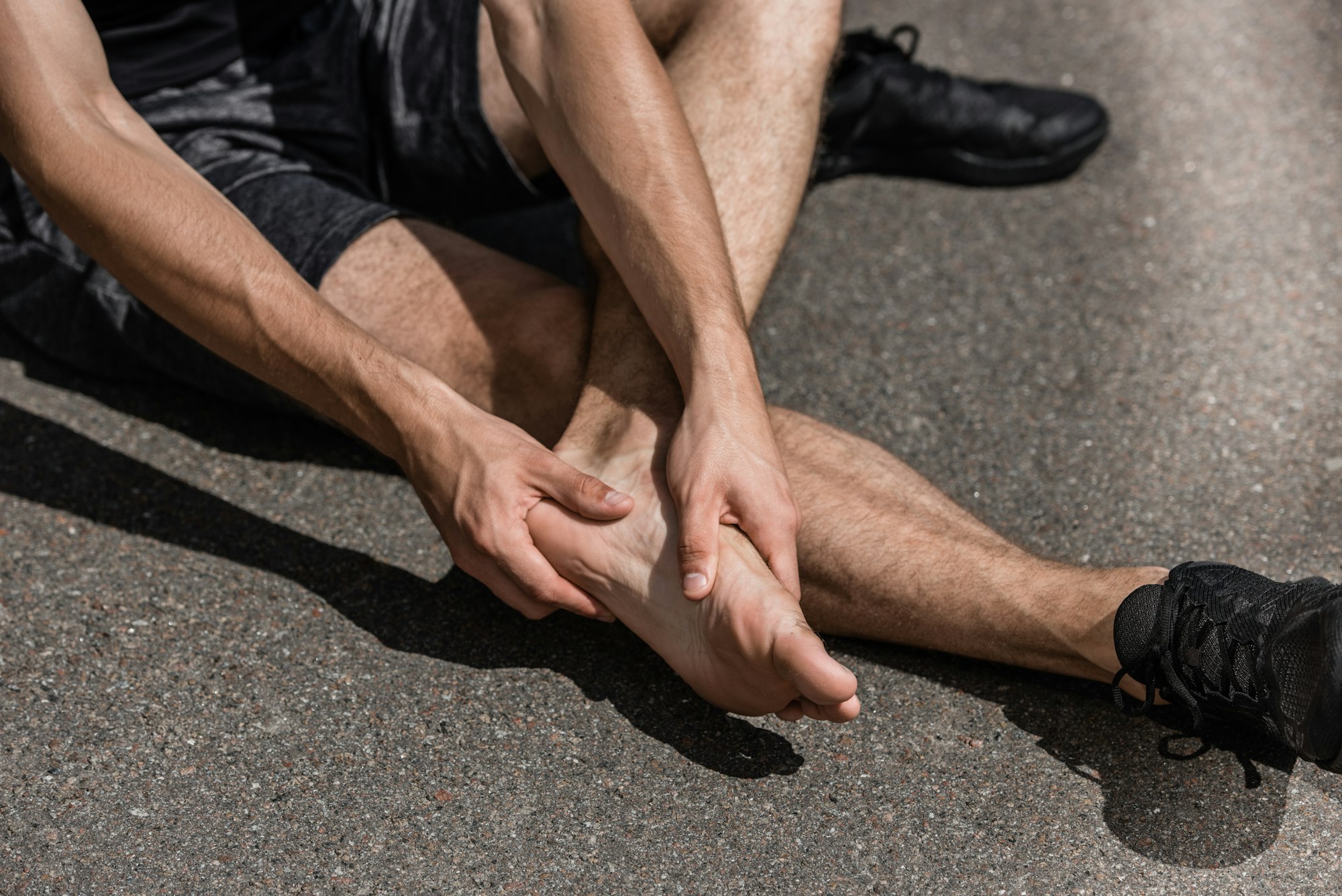 view of barefoot sportsman with foot pain on street