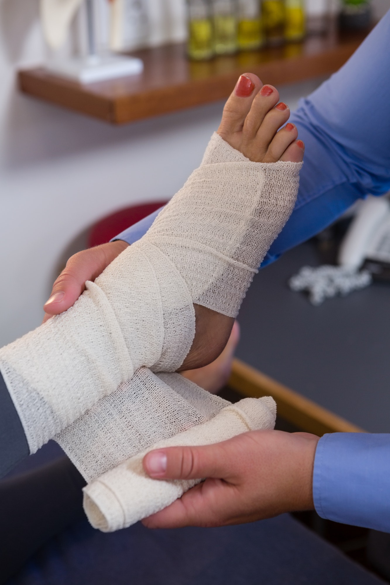 Doctor putting bandage on injured feet of patient