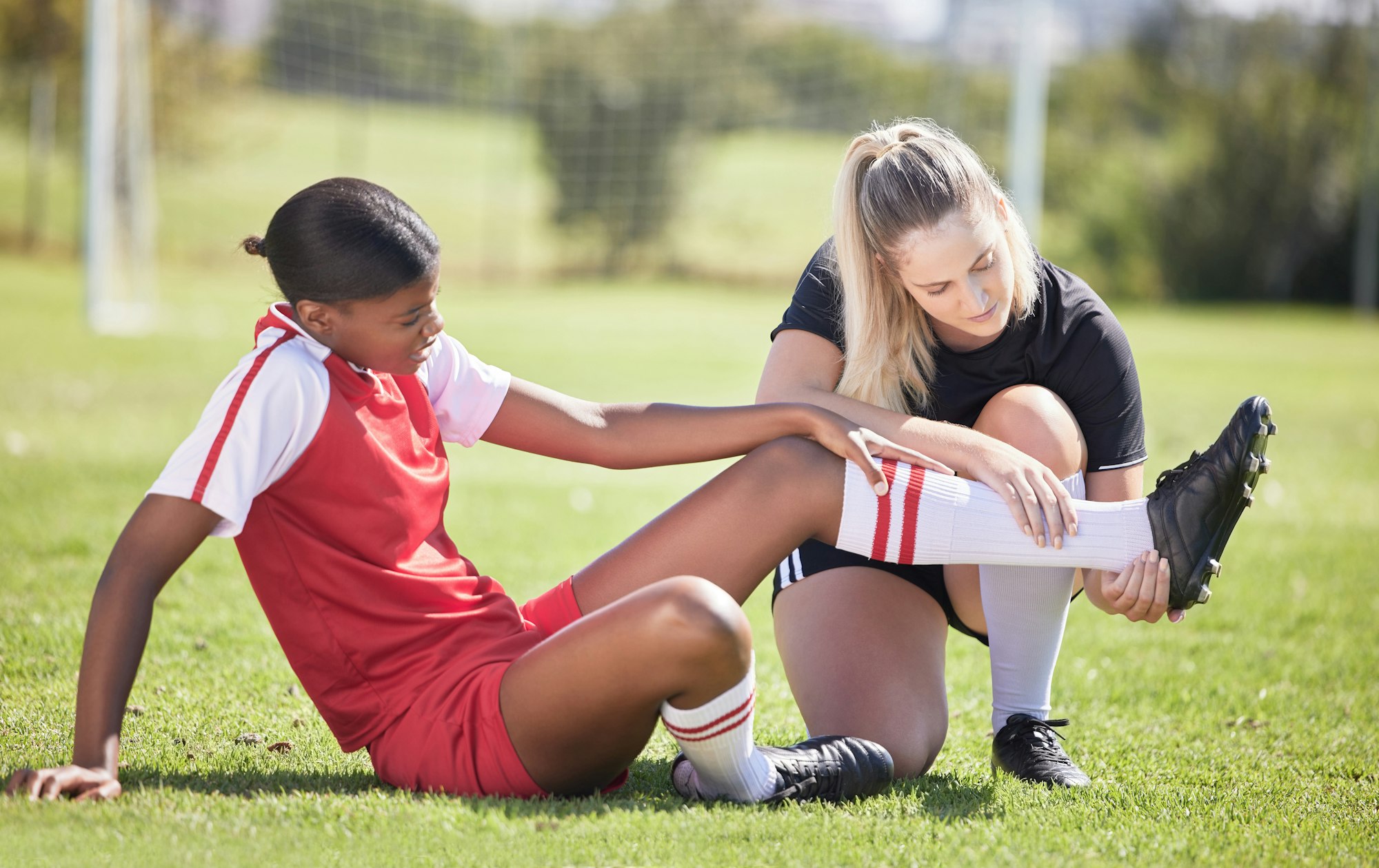 Soccer, sports and injury of a female player suffering with sore leg, foot or ankle on the field. P